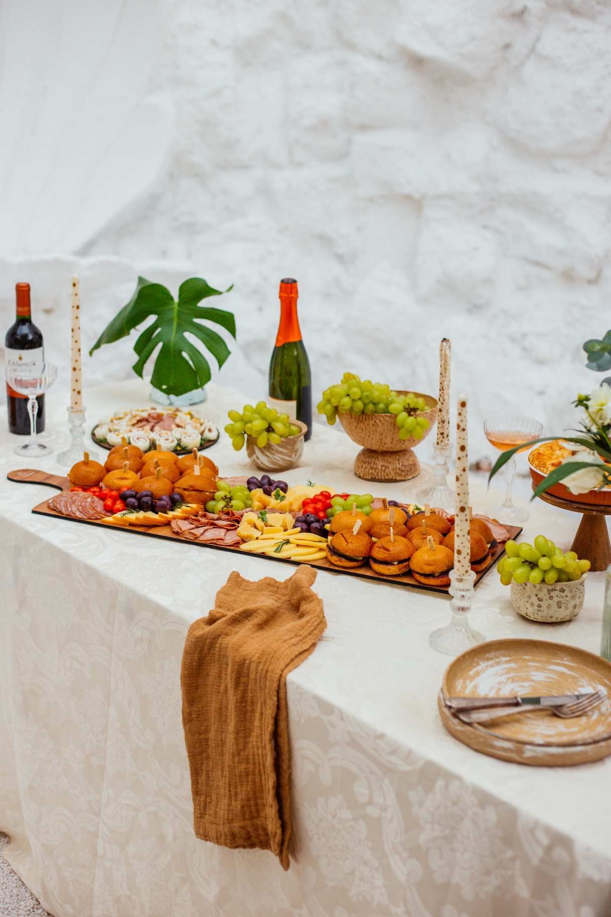 Mesa de evento corporativo com tábua de frios, finger food, frutas e decoração elegante